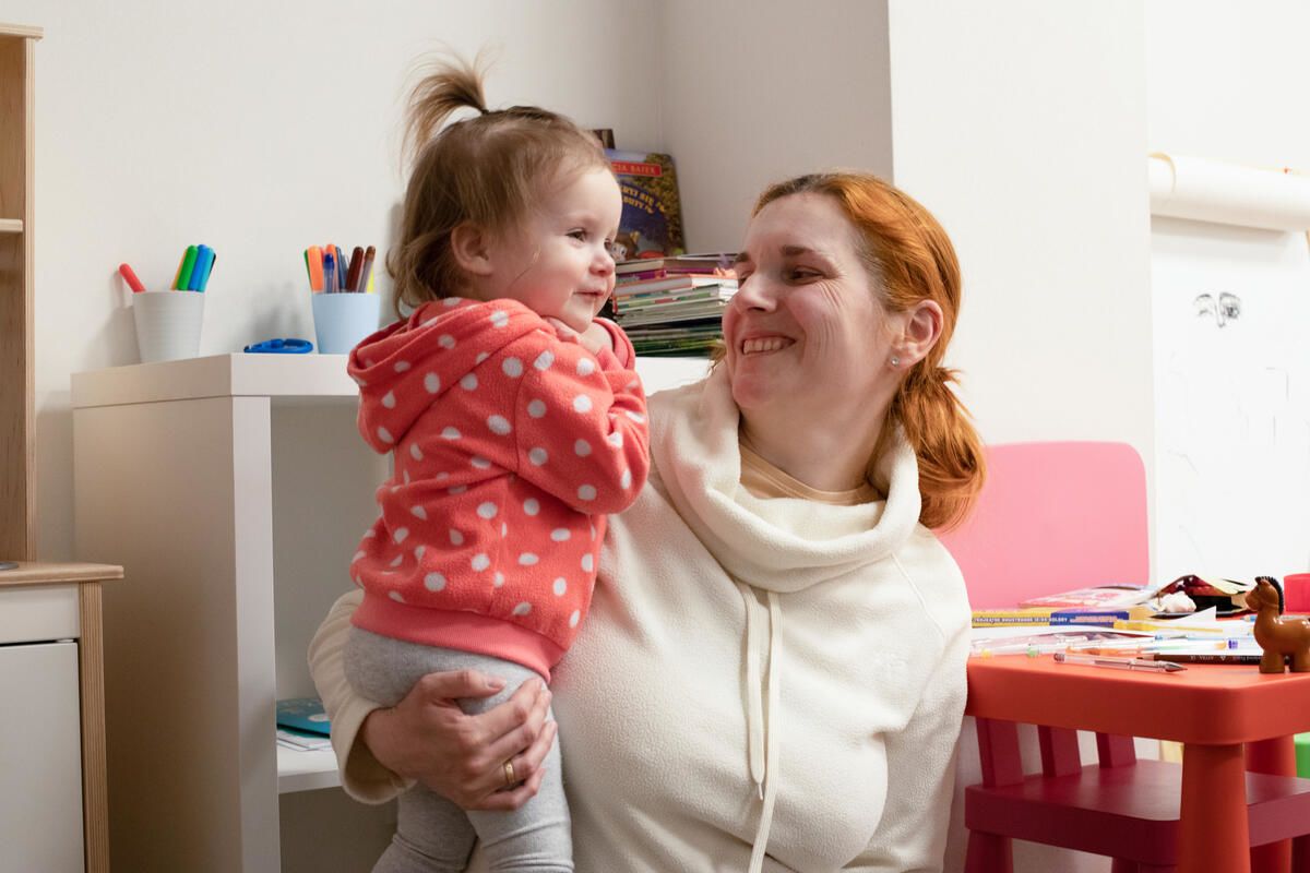 Kristina*, 14 months, is held by her mother Irina*, 36 in the child safe space, Poland