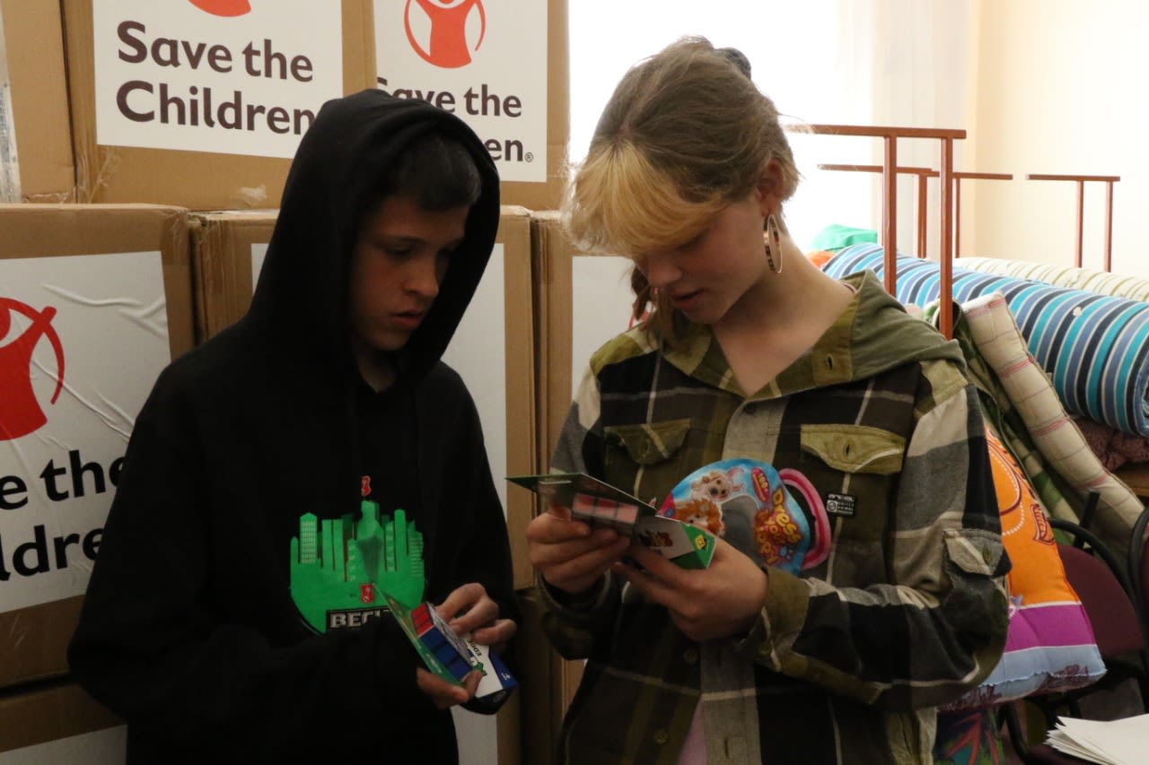 Nastia*, 13, looks at toys from the bunker kits with her foster brothers