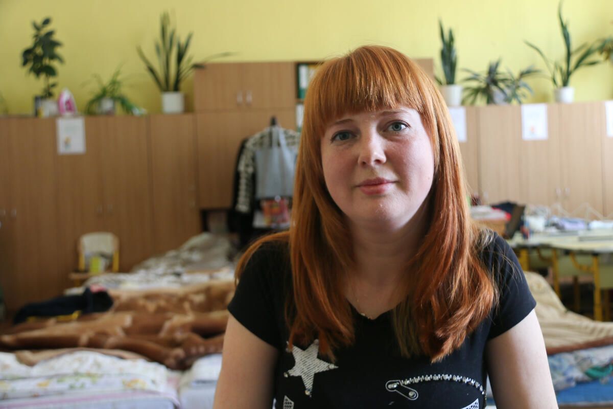 Olena, mother of two, in the classroom where she is now living